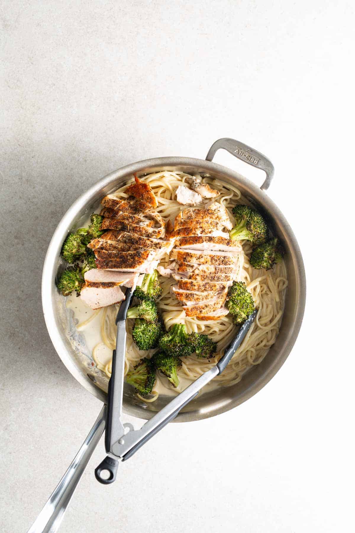 A pan with chicken and broccoli in it.