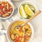 Three bowls of chicken enchilada soup on a table.