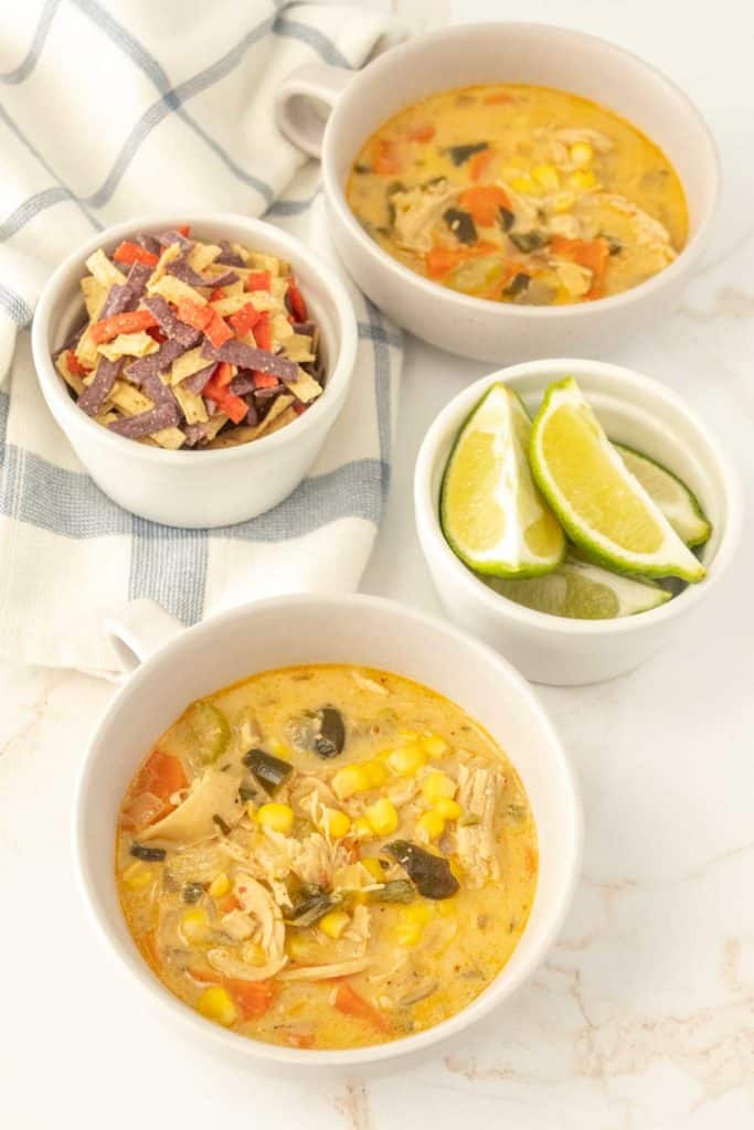 Two bowls of chicken poblano soup on a table.