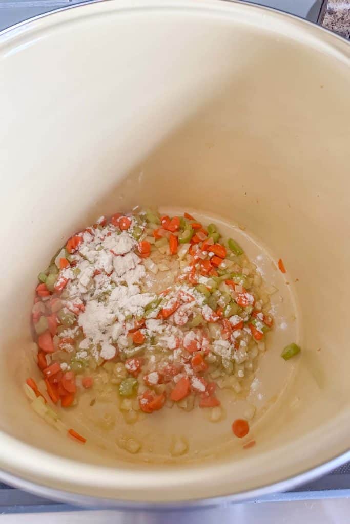 A bowl filled with carrots, celery, and flour.