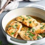 Chicken breasts in a sauce with parsley.