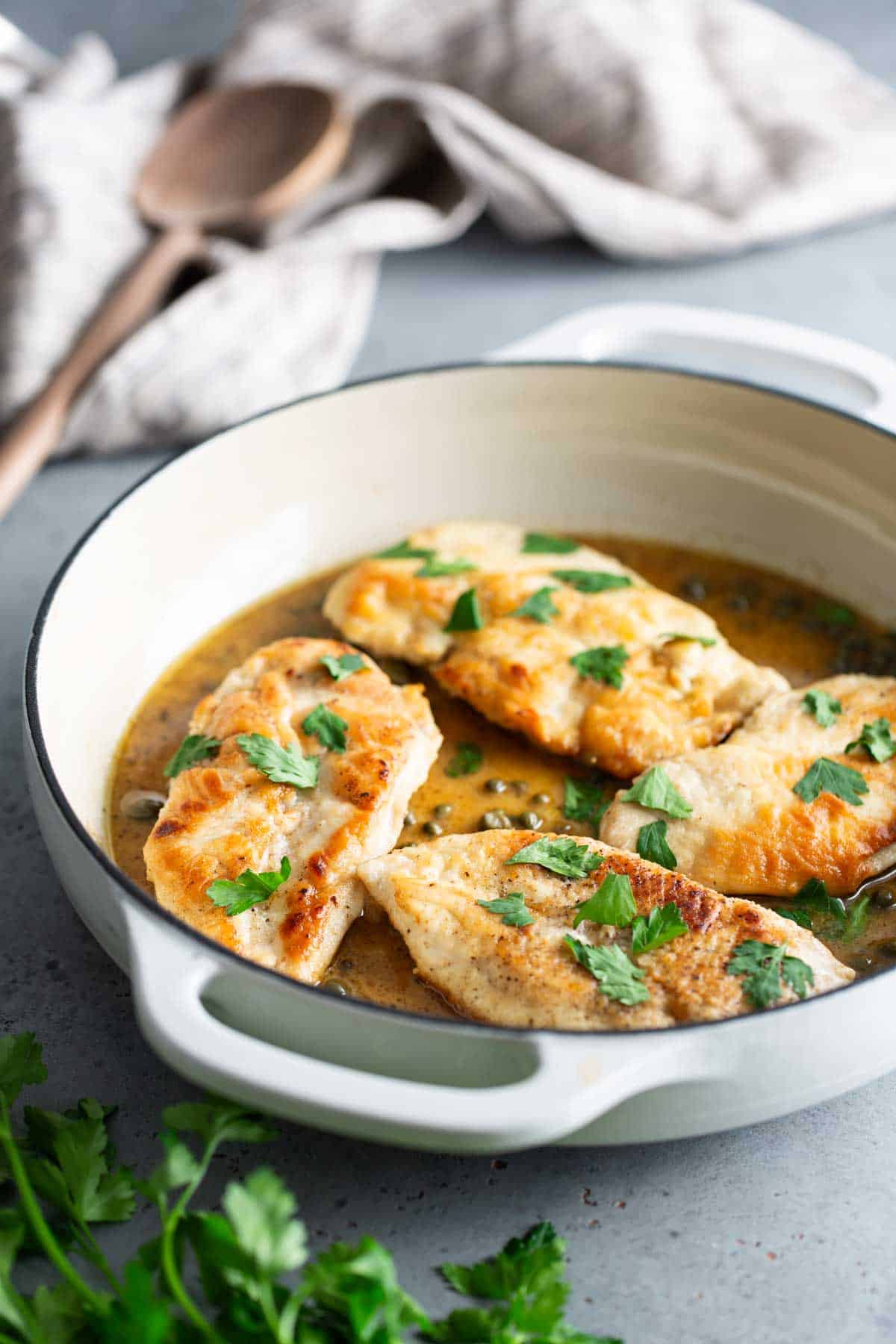 Chicken breasts in a sauce with parsley.