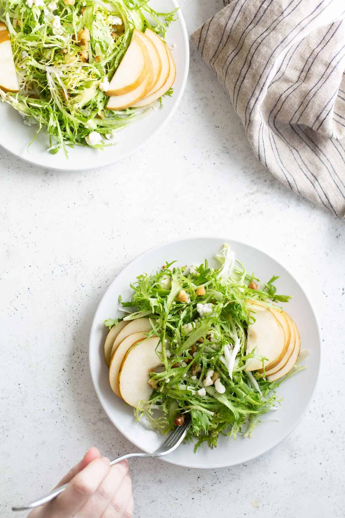 A plate of frisee salad with a fork.