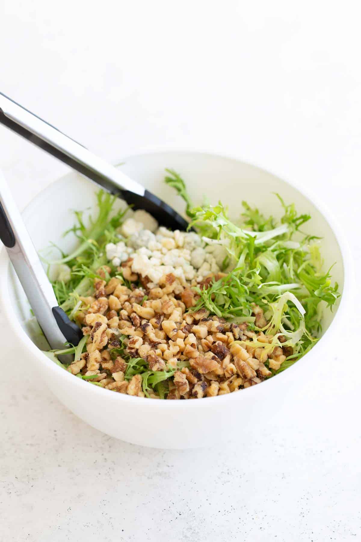 A white bowl with a salad in it.