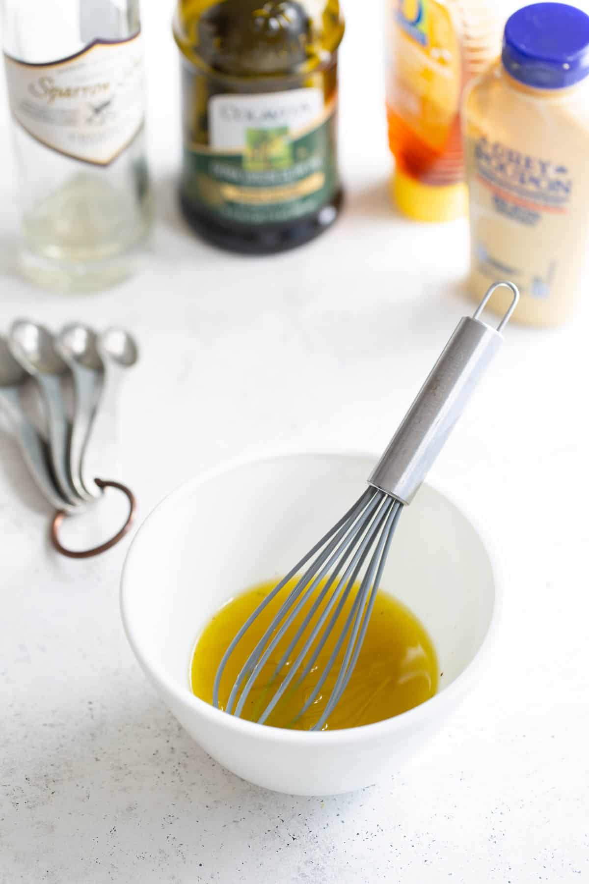 A white bowl with olive oil and other ingredients.