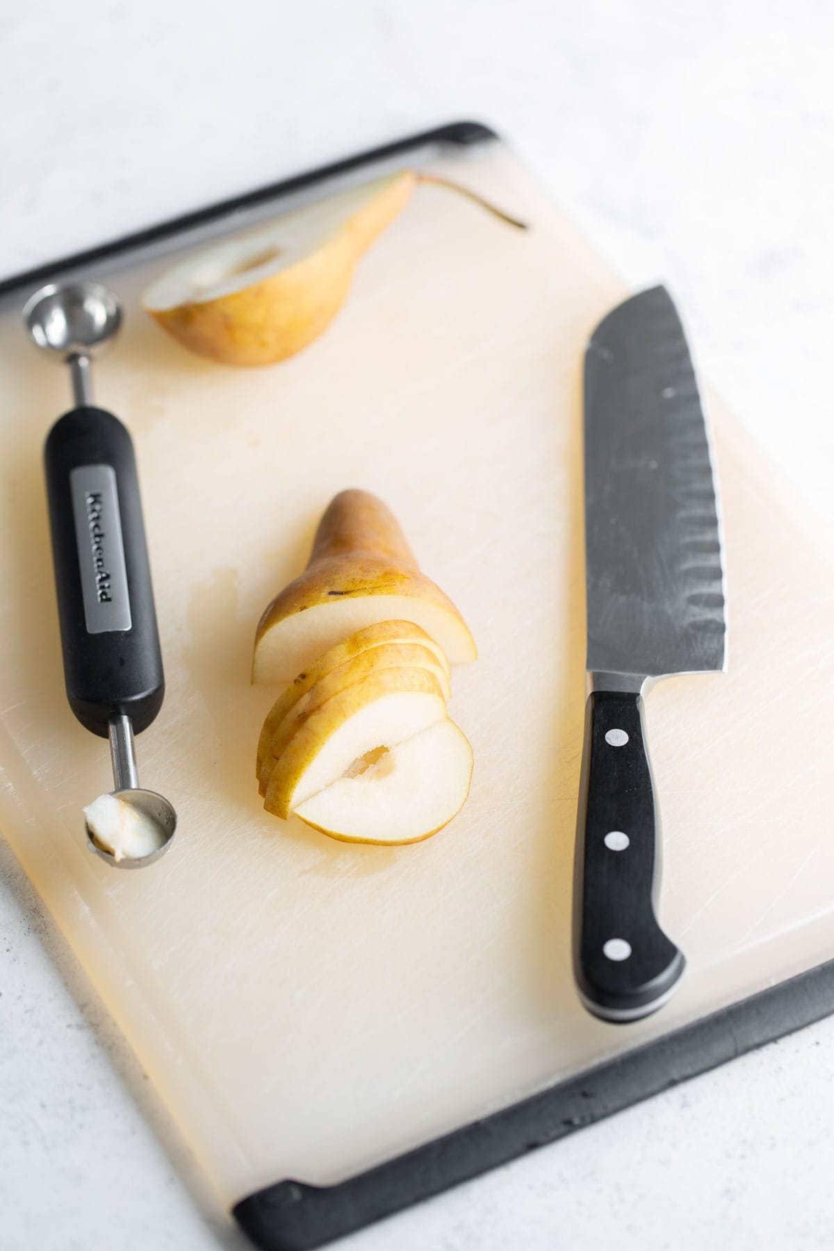 A cutting board with pears and a knife on it.