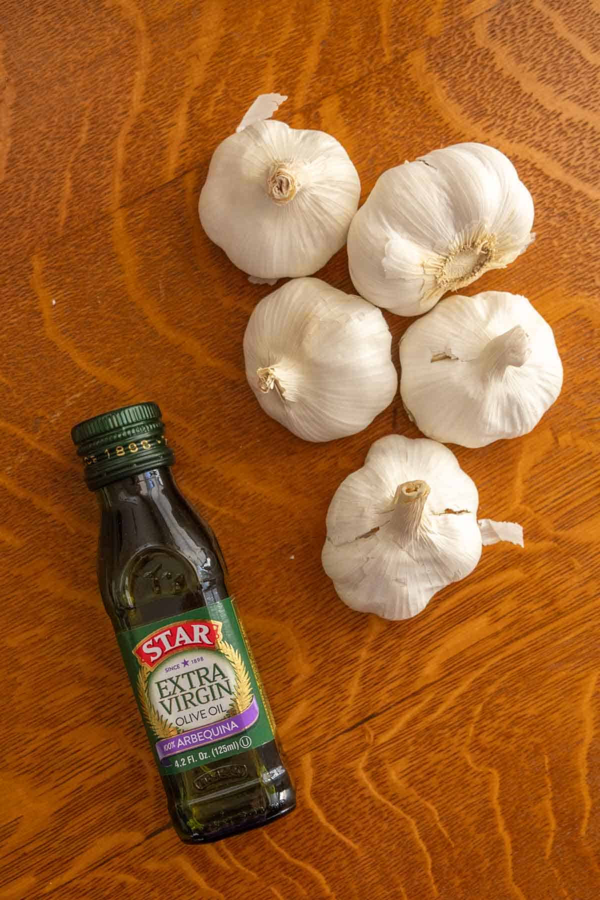 Garlic and olive oil on a wooden table.