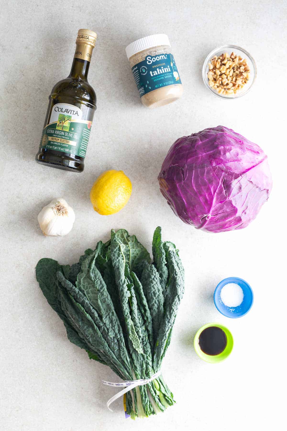 The ingredients for a kale salad are laid out on a table.