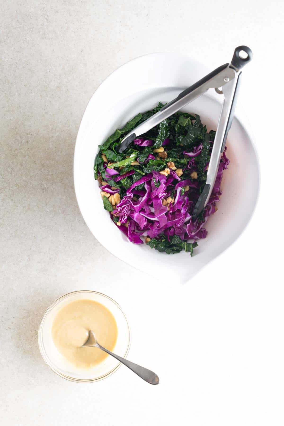 A bowl of slaw and a spoon next to it.