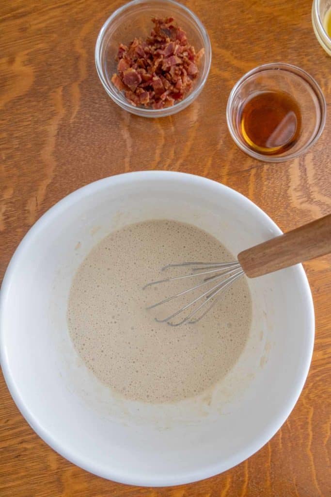 A bowl of ingredients with a whisk in it.