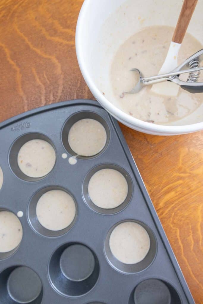 A muffin tin with batter in it.