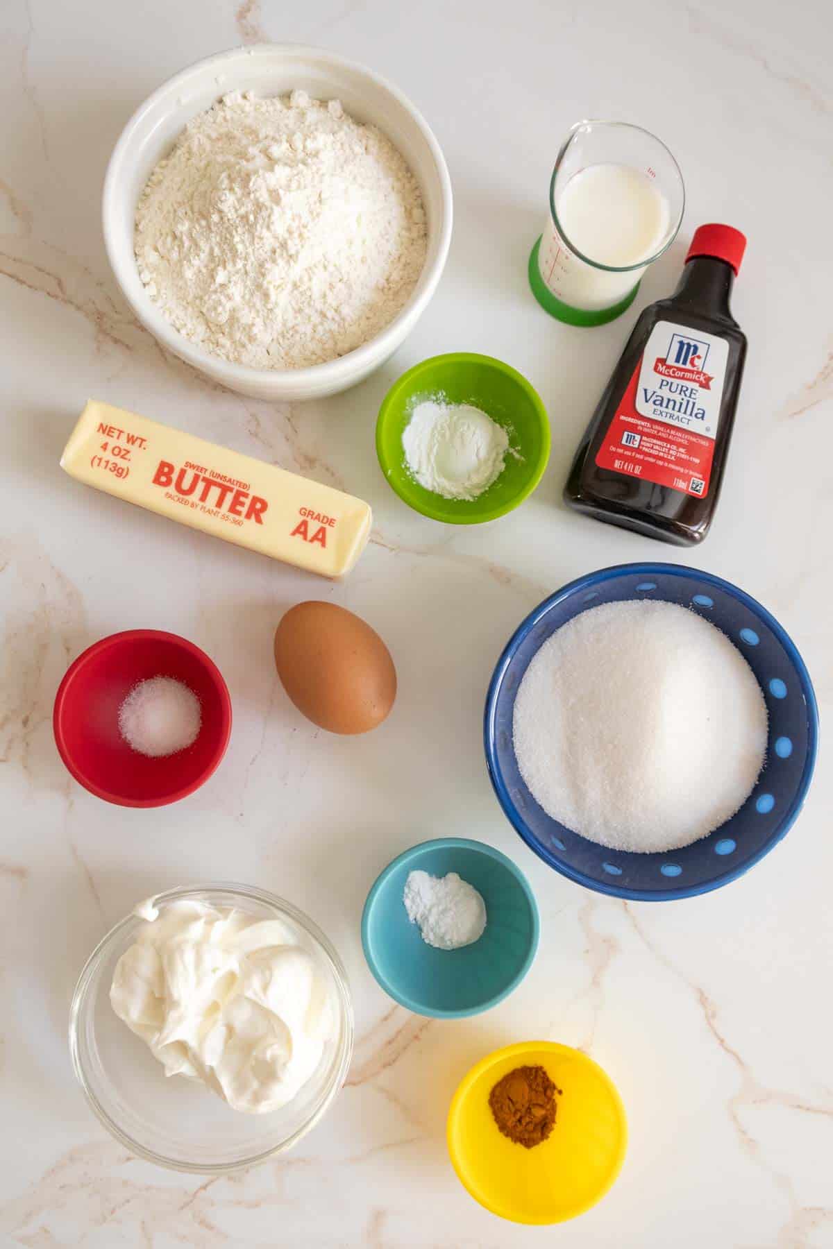 The ingredients for a muffin recipe are laid out on a table.