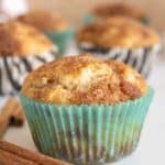 Cinnamon muffins with cinnamon sticks on a white table.