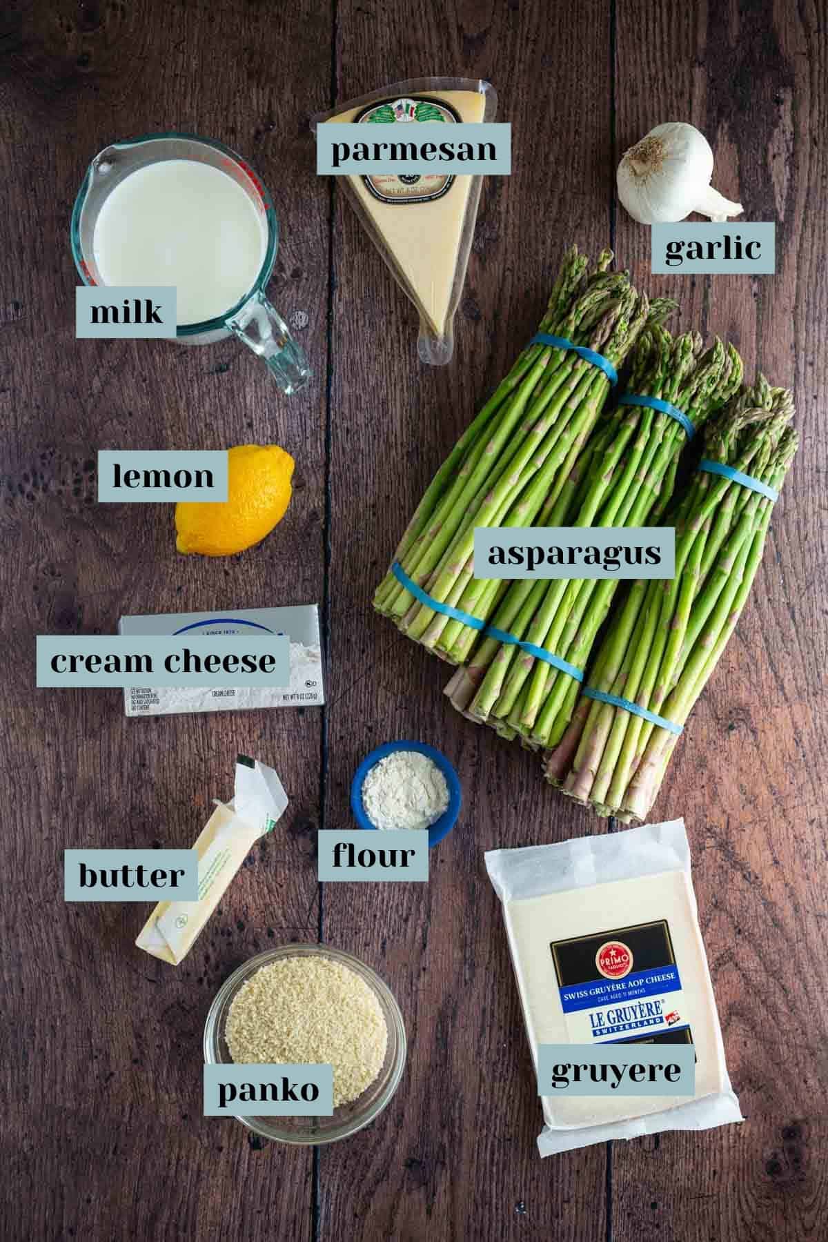 Ingredients for asparagus gratin recipe laid out on a wooden surface.
