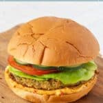 A delicious falafel burger with lettuce, tomato, cucumber, and sauce in a soft bun, served on a wooden board—a perfect choice for fans of falafel burgers.