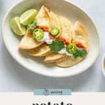 A plate with three folded potato tacos topped with sour cream, salsa, cilantro, and sliced jalapeños, served with lime wedges on the side—these flavorful potato tacos are perfect for any taco lover.