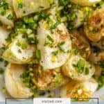 Close-up of roasted turnip pieces garnished with chopped herbs, presented on a plate with a label reading "roasted turnips," showcasing the deliciously golden, oven-roasted turnips ready to serve.