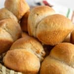 A basket filled with freshly baked, golden-brown bread rolls.