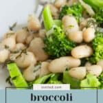 A close-up of broccoli white bean salad with dill and lemon on a plate, featuring green broccoli florets and white beans mixed together.