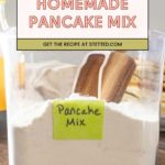A plastic container labeled "Pancake Mix" holds a flour-like mixture with a wooden spoon inside. Text above reads "Homemade Pancake Mix—Get the recipe at stetted.com.