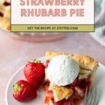 A slice of strawberry rhubarb pie topped with vanilla ice cream sits on a plate with two fresh strawberries; the rest of the pie is in the background.