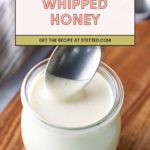 A spoon scoops whipped honey from a small glass jar on a wooden surface, with a text overlay that reads "Whipped Honey. Get the recipe at stetted.com.