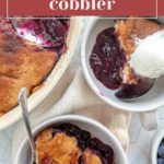 Overhead view of blueberry cobbler in a baking dish with servings scooped into bowls, one topped with a scoop of vanilla ice cream.