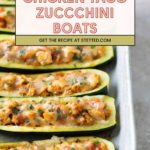 Halved zucchinis filled with chicken taco mixture and melted cheese are arranged in a baking dish.