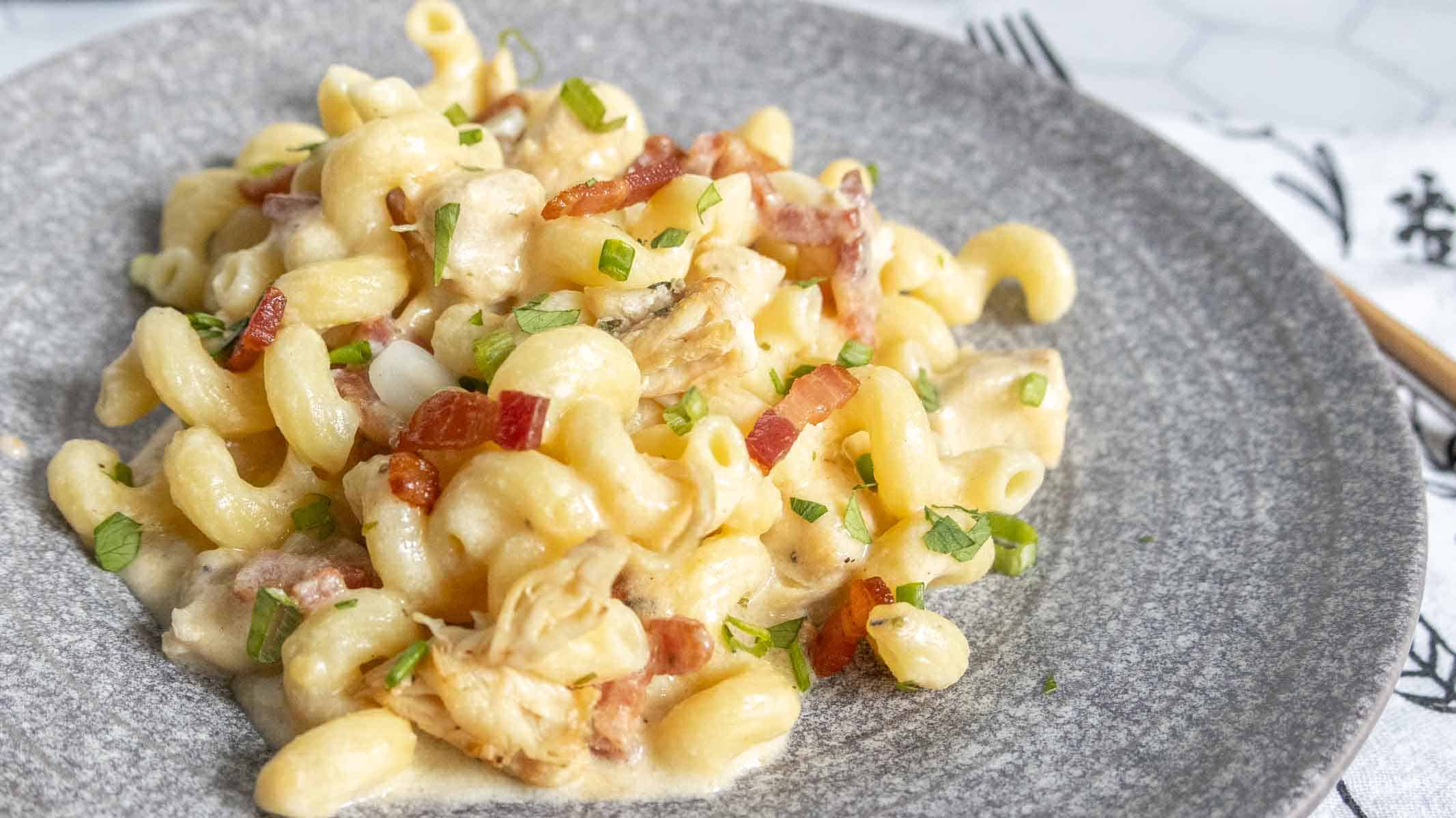A gray plate with a serving of chicken bacon ranch pasta.
