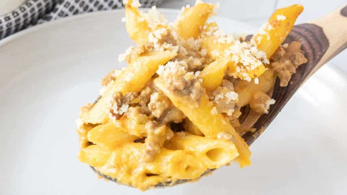 Wooden spoon serving cheeseburger mac and cheese.