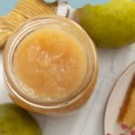 A jar of homemade pear butter on a table, surrounded by fresh pears and a partially visible plate of toast. Text reads "Homemade Pear Butter" and "stetted.com.