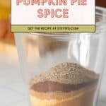 A glass jar holds layered ground spices for Pumpkin Pie Spice, with a label above reading "Pumpkin Pie Spice - Get the recipe at stetted.com." Perfect for adding homemade pumpkin spice flavor to your favorite desserts.
