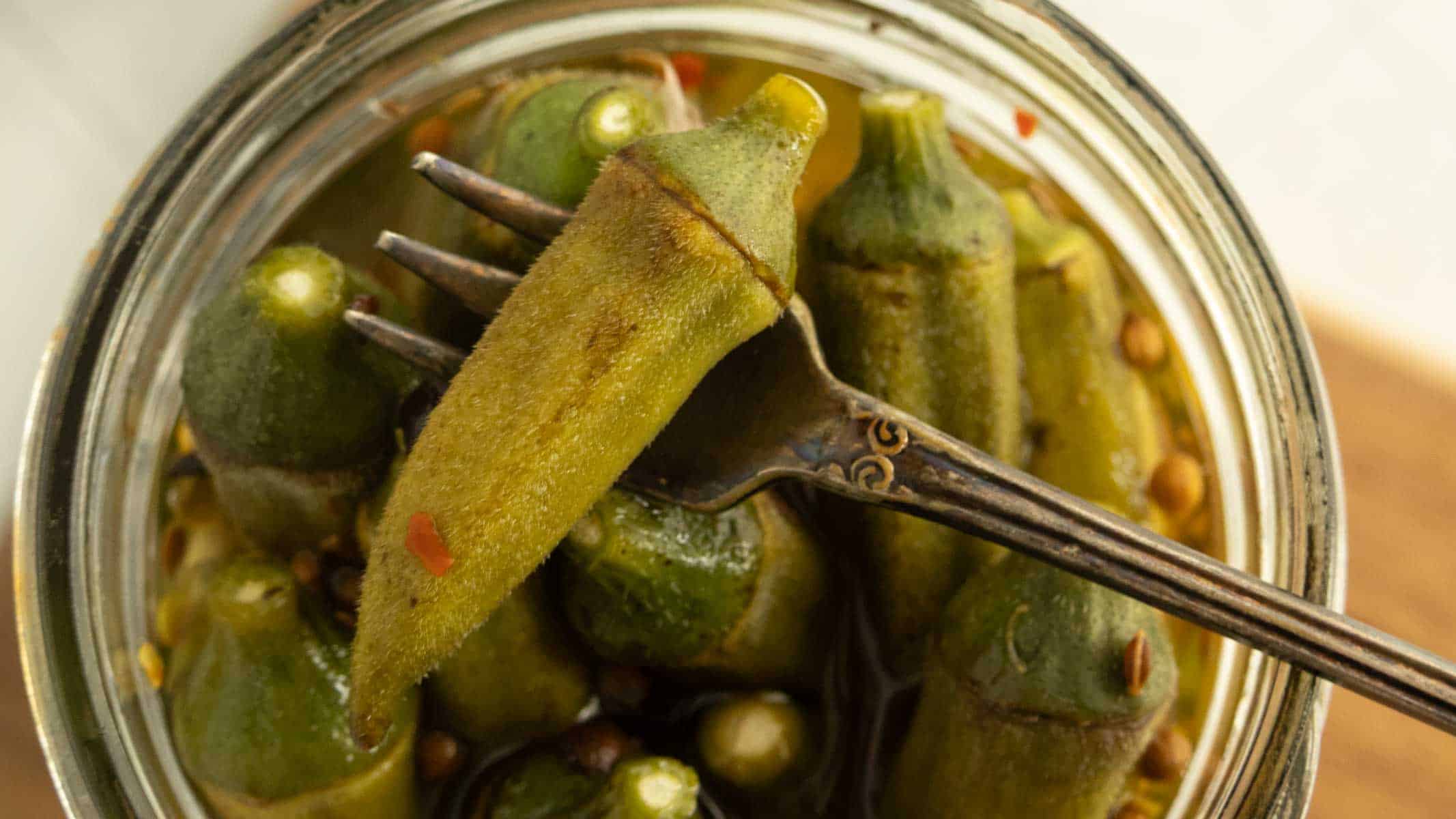 Pickled okra pods in a jar.