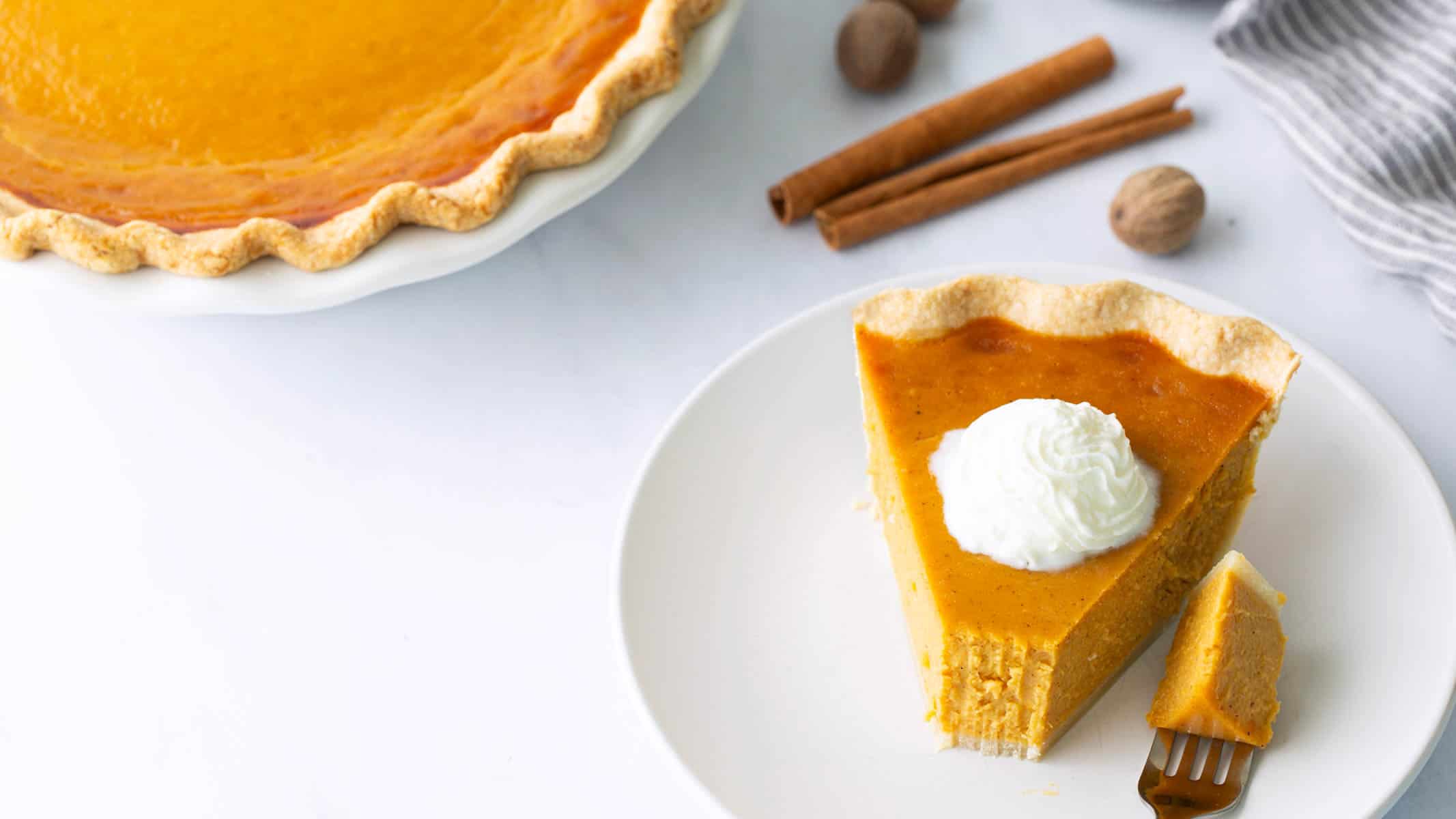 A slice of sweet potato pie with a bite taken.