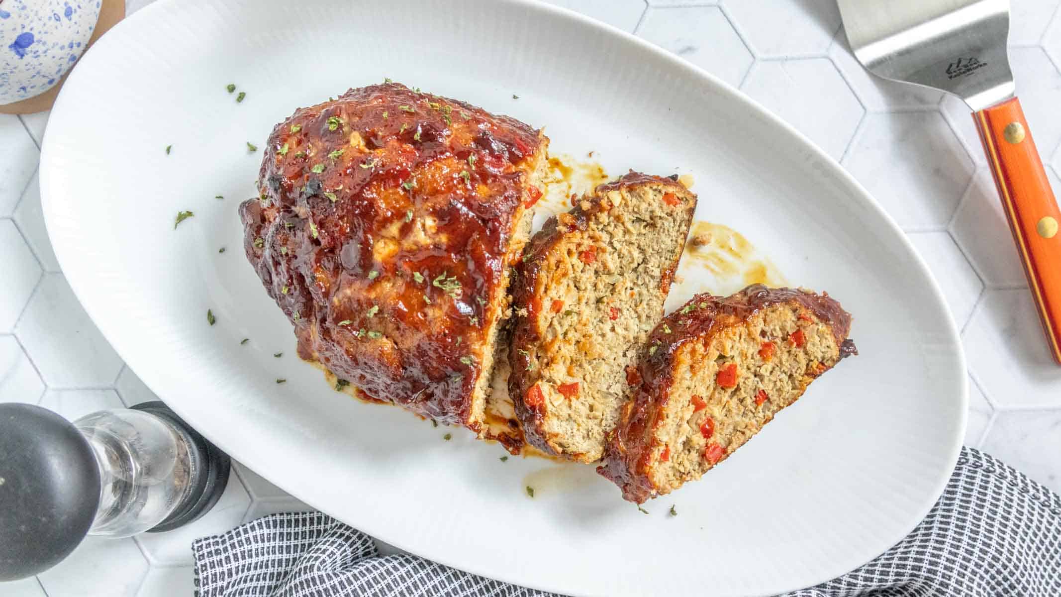 Turkey meatloaf sliced on a white platter.
