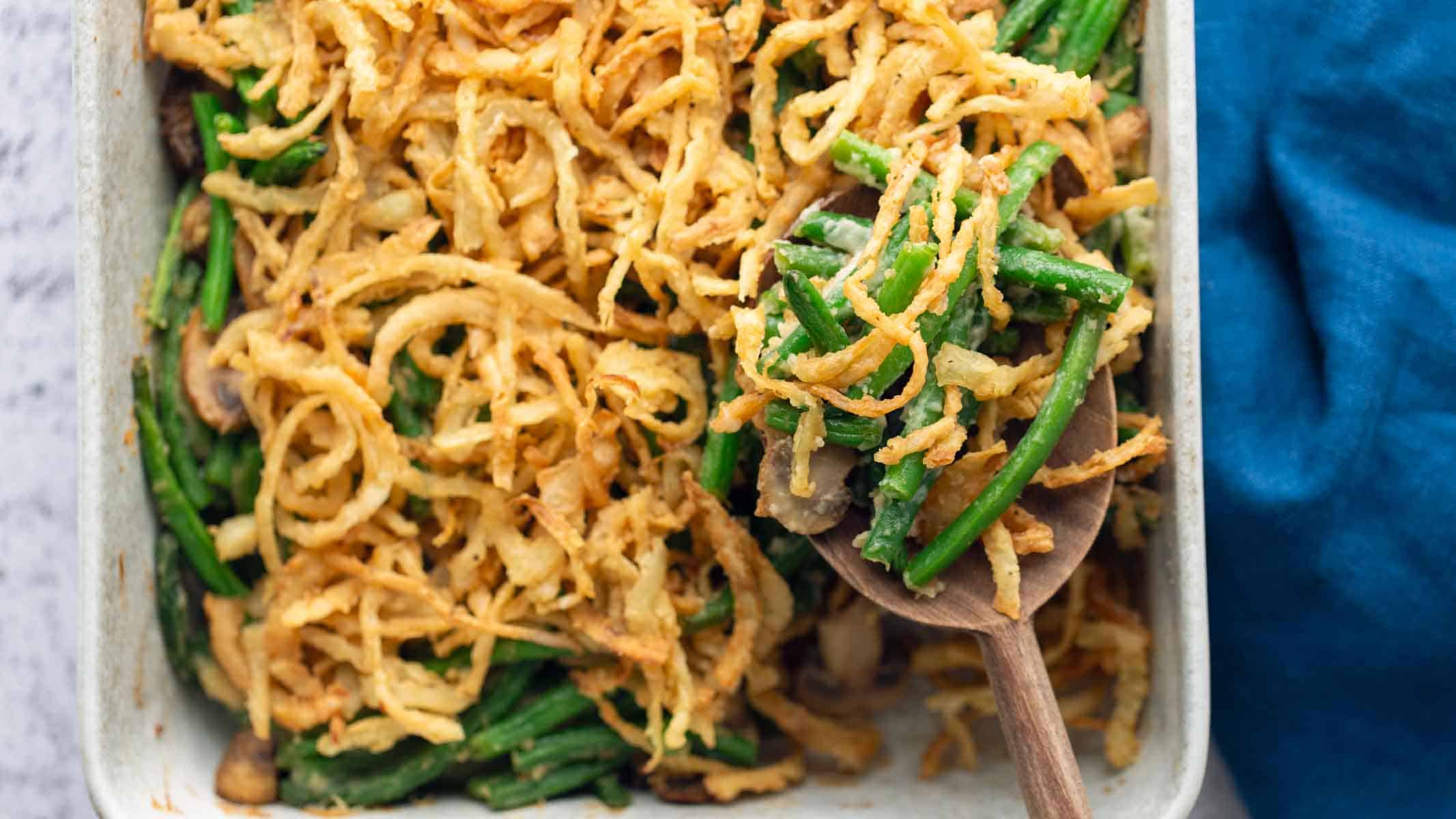 Green bean casserole with a spoon lifting some out of the pan.