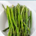 A white bowl filled with cooked asparagus spears sits on a table under text that reads "easy sautéed asparagus.