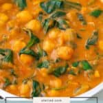 A bowl of chickpea curry with spinach in a rich, orange-colored sauce.