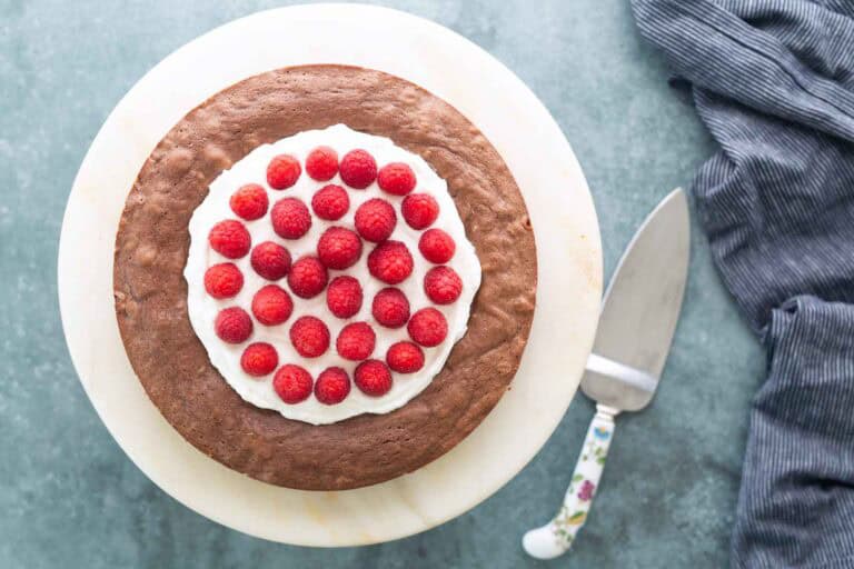 A Swedish chocolate cake topped with whipped cream and raspberries.