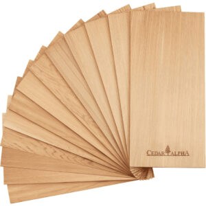 A fan arrangement of sixteen thin cedar wood sheets, reminiscent of the traditional cedar plank salmon grilling method, with “Cedar Alpha” and a tree logo engraved on the bottom right of the top sheet.
